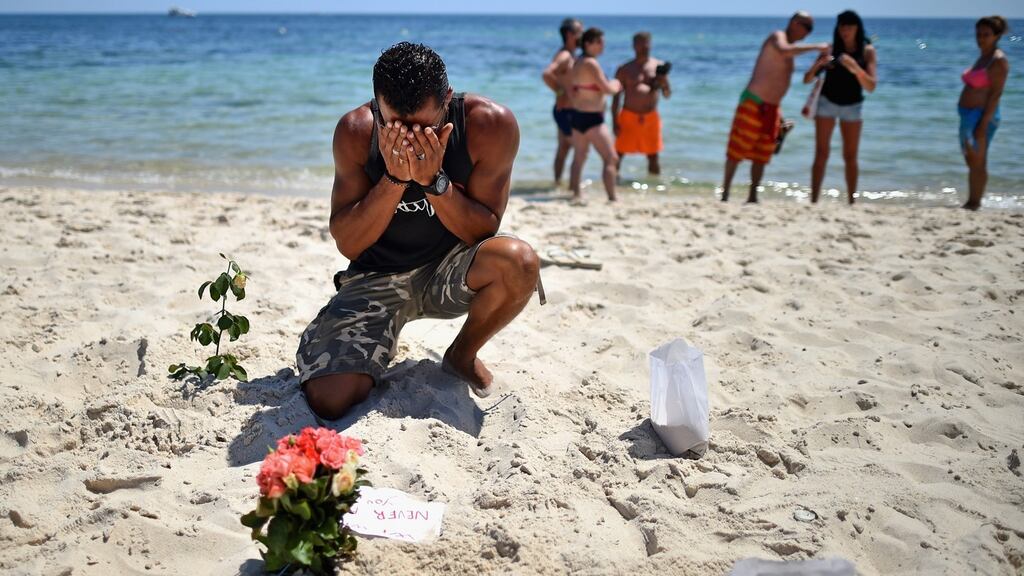 A man lays flowers on Marhaba beach where 38 people were killed on Friday.   Photograph: Jeff J Mitchell/Getty Images