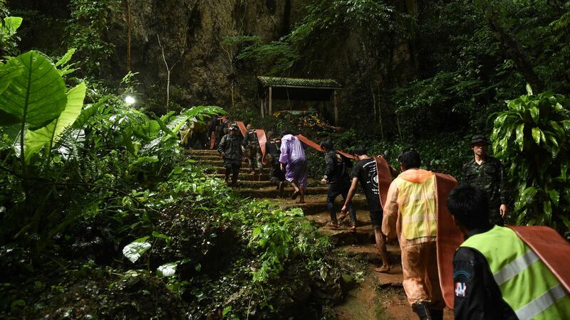 Thai rescuers carry hose to the Tham Luang cave to pump out water. Photograph: Lillian Suwanrump/AFP/Getty Images