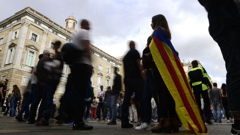 A woman wrapped with a pro-independence Estelada Catalan flag stands outside Catalonia’s Generalitat Palace in Barcelona on Saturday. Photograph: AFP/Getty Images