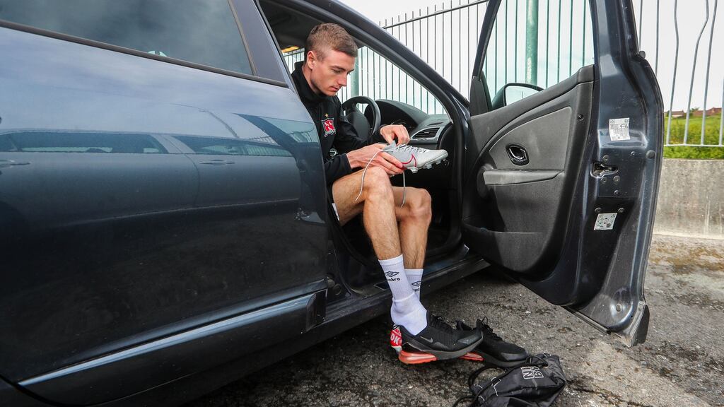 Dundalk’s Daniel Kelly puts on his boots in his car ahead of a return to training at Oriel Park on Wednesday. Photograph: Ryan Byrne/Inpho