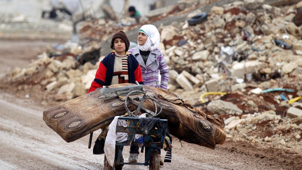 Samah, 11, and her brother, Ibrahim, transport their salvaged belongings from their damaged house in Doudyan village in northern Aleppo Governorate, Syria, Photograph: Khalil Ashawi/Reuters