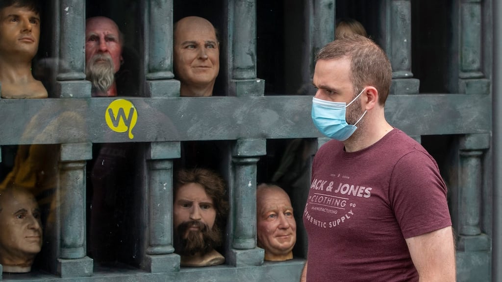 A man, wearing a protective facemask, passes the window of the Wax Museum, Dublin city centre, which remains closed due to Level 3 restrictions to tackle the spread of Covid-19 in Co Dublin. Photograph: Collins Photos