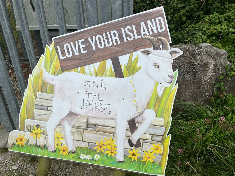 Graffiti protesting against the Bibby Stockholm barge on a sign on the Verne hilltop overlooking the vessel and Portland town. Photograph: Mark Paul