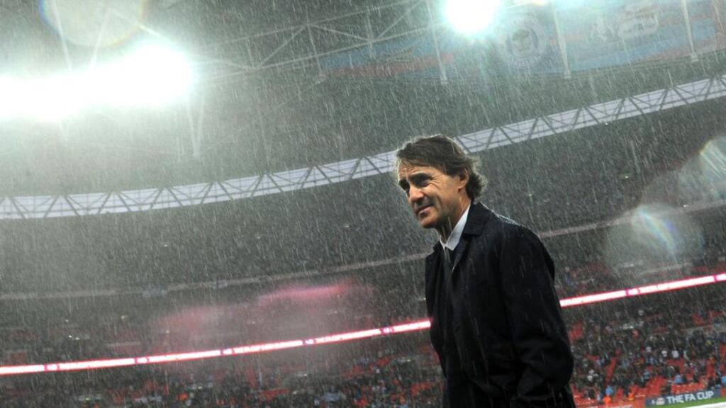 Manchester City manager Roberto Mancini leaves the pitch following the FA Cup Final defeat to Wigan at Wembley Stadium. Photograph: Anthony Devlin/PA Wire