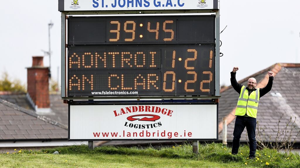 Steward Conor McCaffrey celebrates next to the scoreboard after Antrim beat Clare last week. Photo: Laszlo Geczo/Inpho