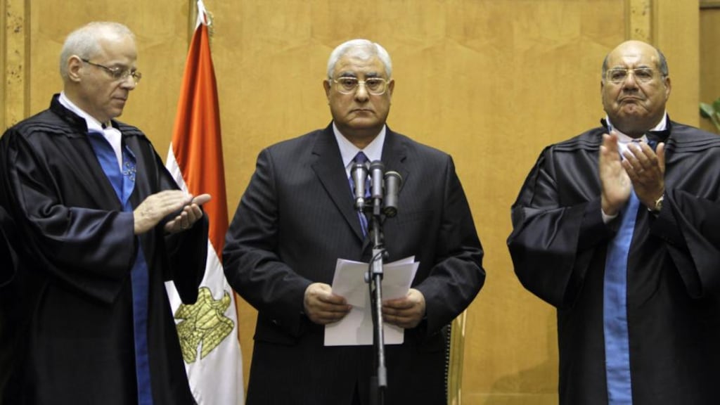Egypt’s chief justice Adly Mansour (centre) being  applauded by chiefs of the constitutional court after he was sworn in as the nation’s interim president yesterday. Photograph: Amr Nabil/AP