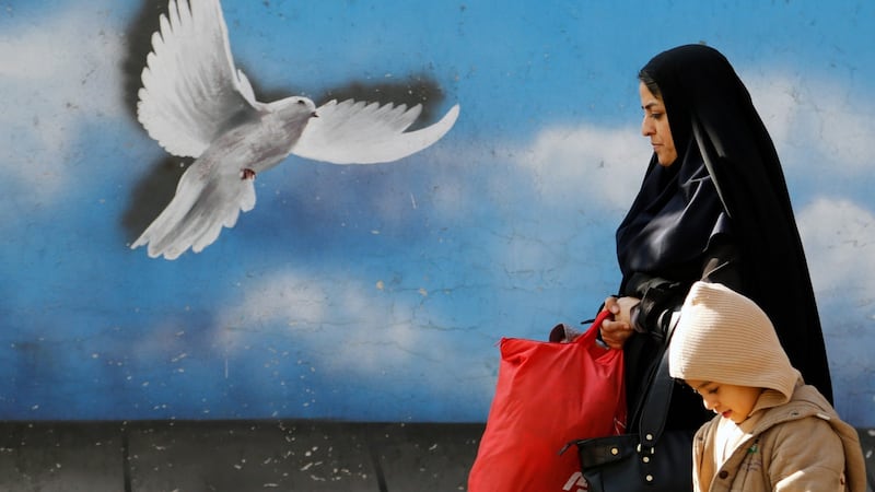 An Iranian woman with her child walk passes in a street of the capital of Tehran, Iran on Saturday. Iranians are waiting for the announcement from International Atomic Energy Agency (IAEA) to declare the end of Iran’s nuclear issue and sanctions lifted. Photograph: EPA