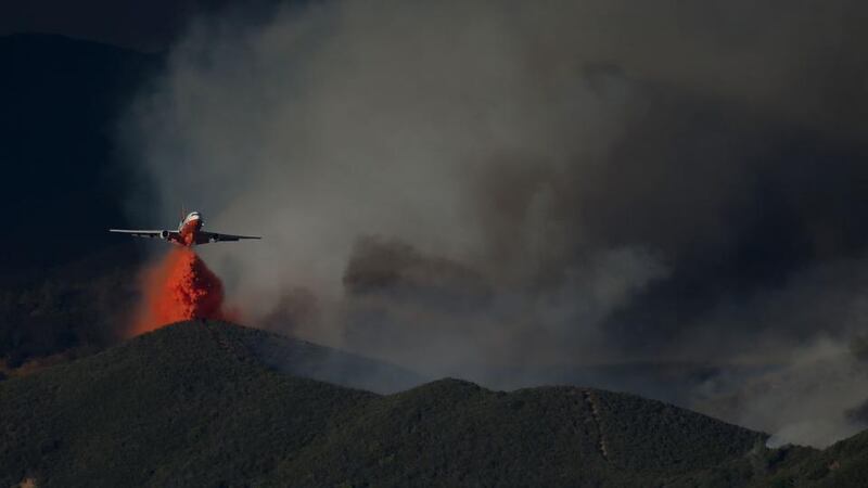 A DC-10 firefighting aircraft drops fire retardant on a ridge in front of the Rocky Fire. Photograph: Justin Sullivan/Getty Images