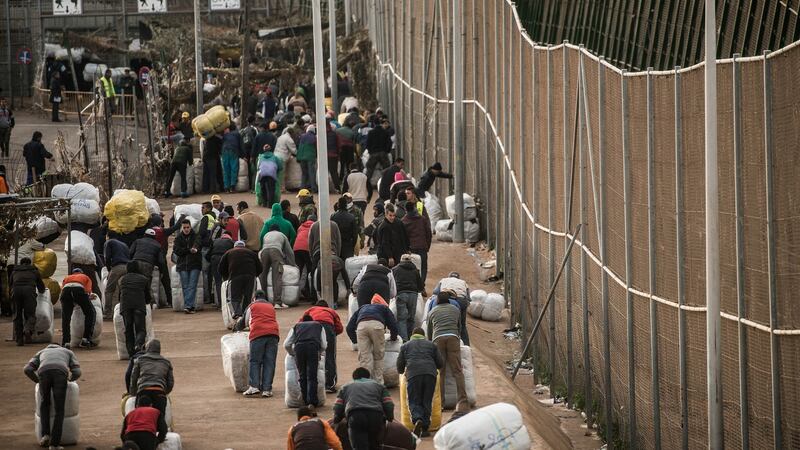 People carry packages on their back as they cross the Barrio Chino border crossing point between Melilla and Morocco. Photograph: Getty Images