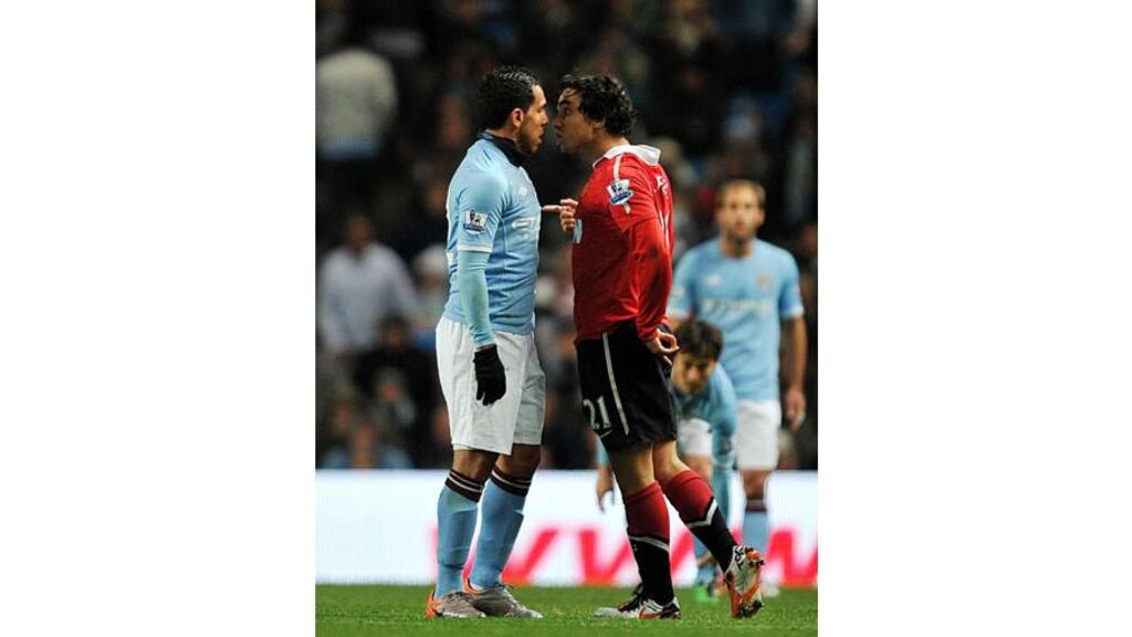 Carlos Tevez and Rafael Da Silva exchange pleasantries during the first half of tonight’s scoreless draw at Eastlands. Photograph: Martin Rickett/PA Wire