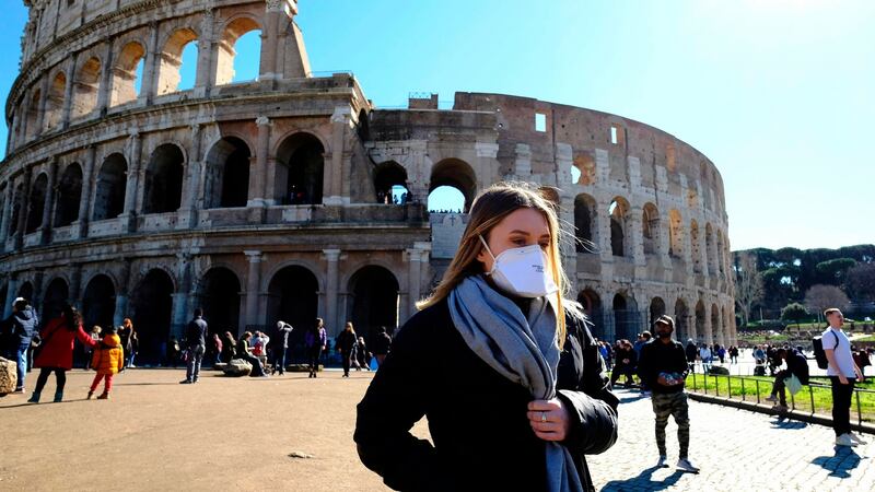 Tourist wearing a protective respiratory mask tours outside the Colosseo monument in downtown Rome on Friday. Photograph: Andreas Solaro/AFP