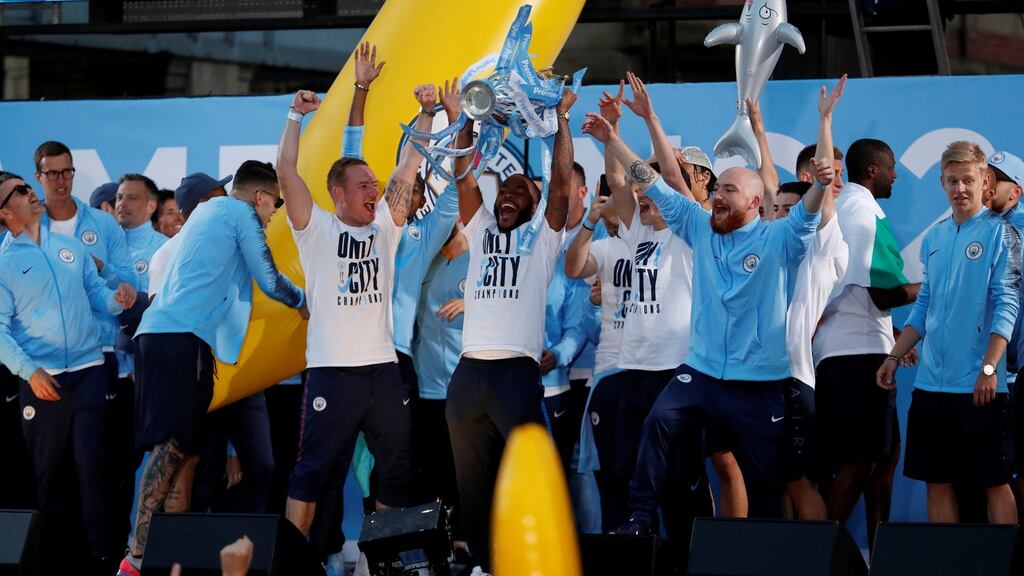 Manchester City’s Raheem Sterling lifts the Premier League trophy during the parade. They will start the 2018/19 season away to Arsenal. Photo: Andrew Boyers/Reuters