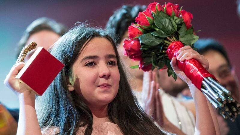 Hana Saeidi, the niece of Iranian film director Jafar Panahi appears on stage with jury members and prize winners after accepting the Golden Bear for Best Film on her uncle’s behalf, during the awards ceremony at the 65th Berlinale International Film Festival in Berlin. Photograph: AFP