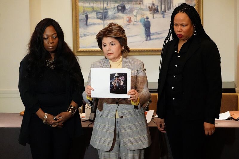 From left to right: Rochelle Washington, lawyer Gloria Allred and Latresa Scaff hold up a photo as they speak at a press conference to make accusations against singer R Kelley in New York City on February 21st. Photograpgh: Carlo Allegri/Reuters