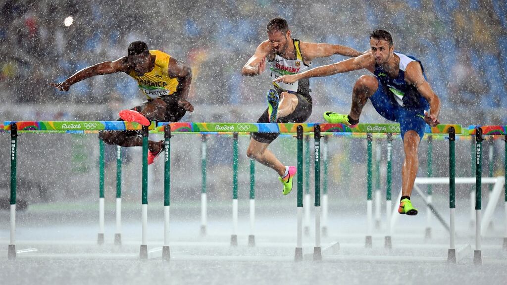 The men’s 110m hurdles heats underway under heavy rain in Rio. Photograph: EPA
