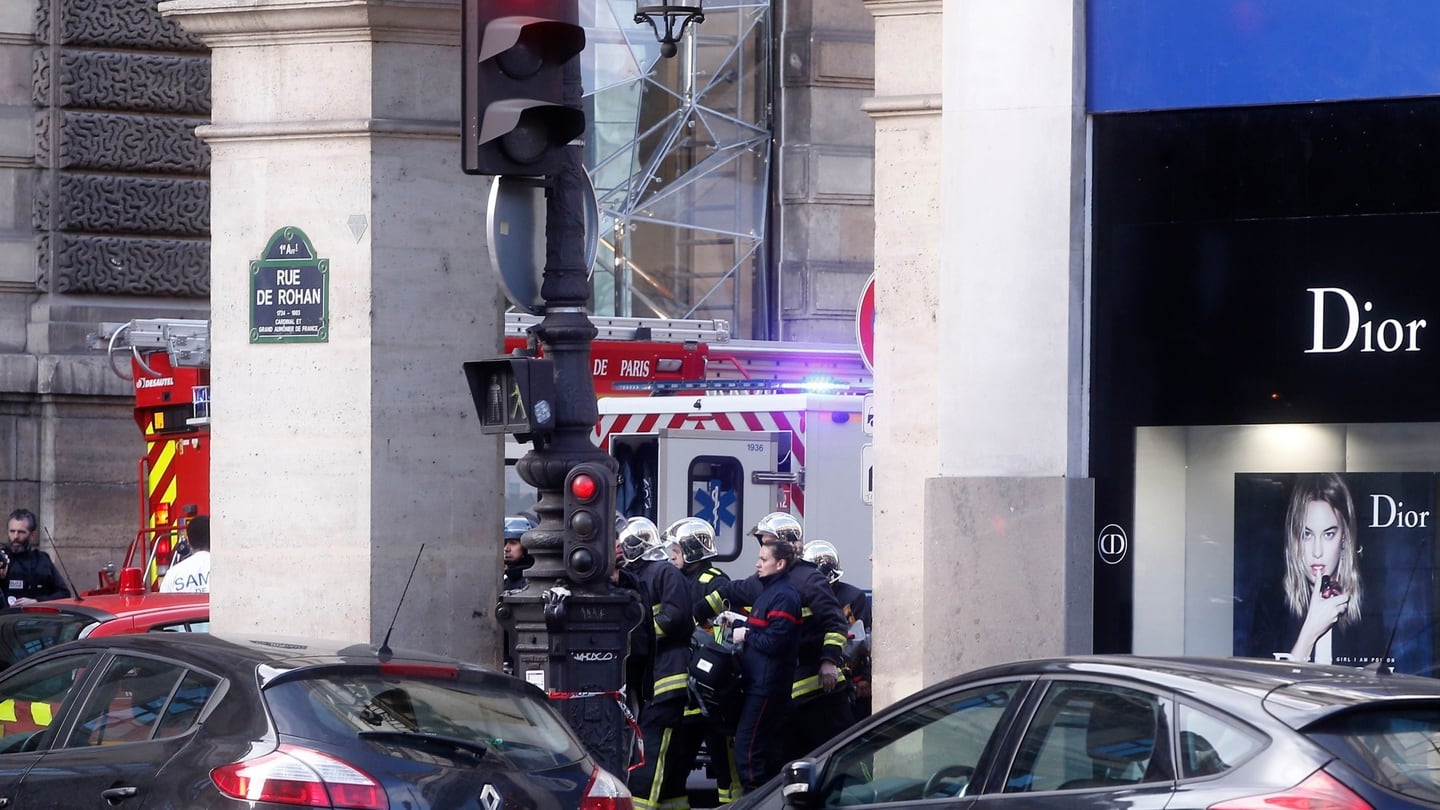 Rescue workers carry a stretcher outside the Louvre museum. Photograph: Thibault Camus/AP