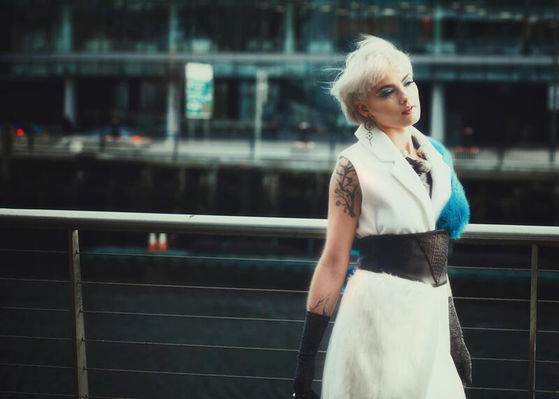 Cream gilet (€119) and grey boots (€169) both from Monreal, blue faux fur stole, €36, socks ,€5 and earrings, €18.50 from Isobella Ru, Cork. Leather belt, €85, at  On the Verge. Recycled rubber neckpiece €75, MVM Art & Design from Wild Designs, Cork. Vintage lurex gloves €20 at The Hummingbird Rooms, Cork