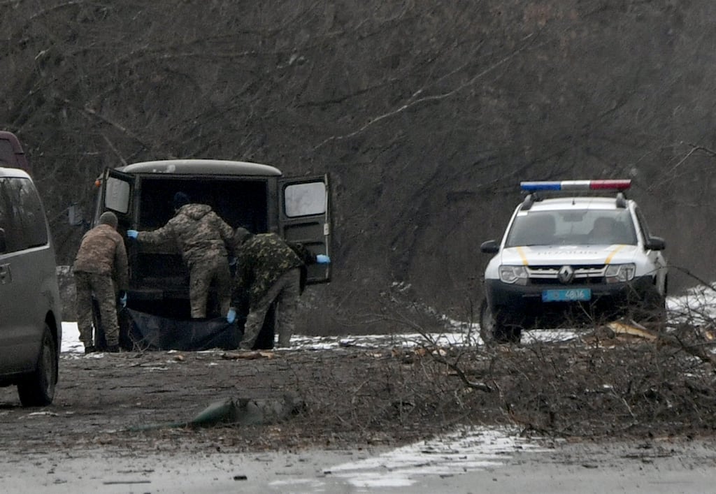Policemen place the body of a civilian in a car following a Russian missile strike on the industrial zone of Kyiv on Thursday. Photograph: Sergei Supinsky/Getty Images