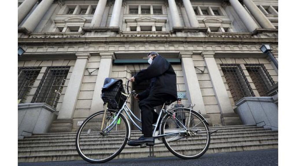 A man cycles past the Bank of Japan headquarters in Tokyo. Photograph: Tomohiro Ohsumi/Bloomberg