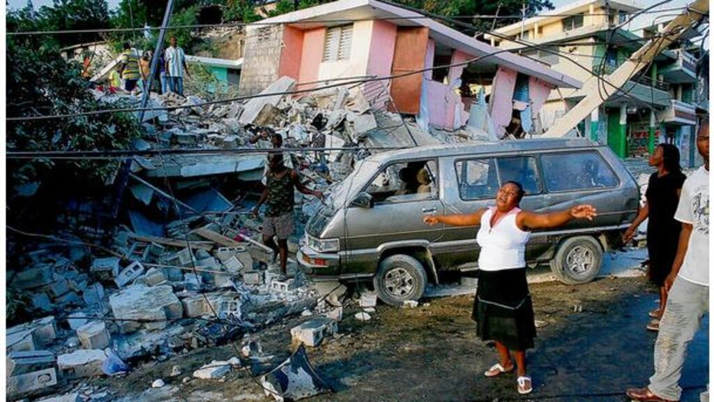 Residents near destroyed buildings after the earthquake in Port-au-Prince yesterday. All of the capital's hospitals were destroyed or abandoned because they were unsafe, and aid groups set up makeshift hospital tents alongside them. Photograph: Eduardo Munoz/Reuters