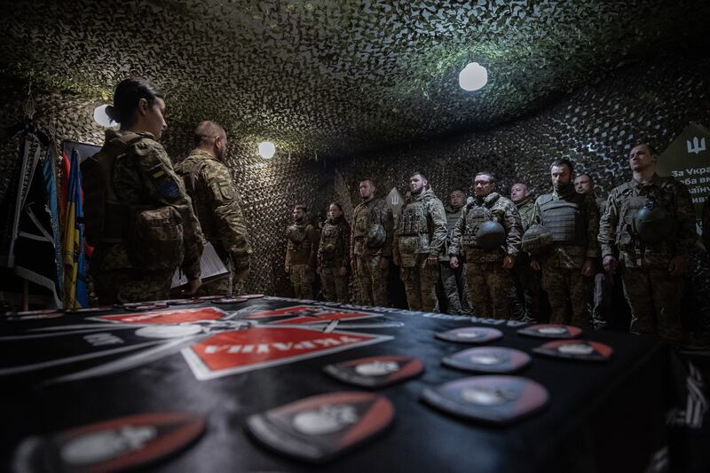 Ukrainian soldiers on the front lines take part in a ceremony handing over badges to new members of the army. Photograph: EPA