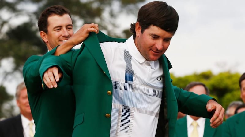 Defending Masters Champion Adam Scott of Australia helps Bubba Watson of the US (right) into his second green jacket after winning the  Masters in Augusta. Photograph: EPA