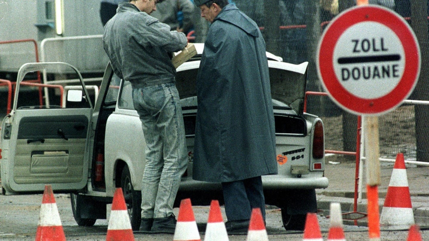An East German civilian shows an East German customs officer the contents of his Trabant  car at checkpoint Potsdamer Platz in East Berlin in  November 1989. Photograph: Michael Probst/Reuters