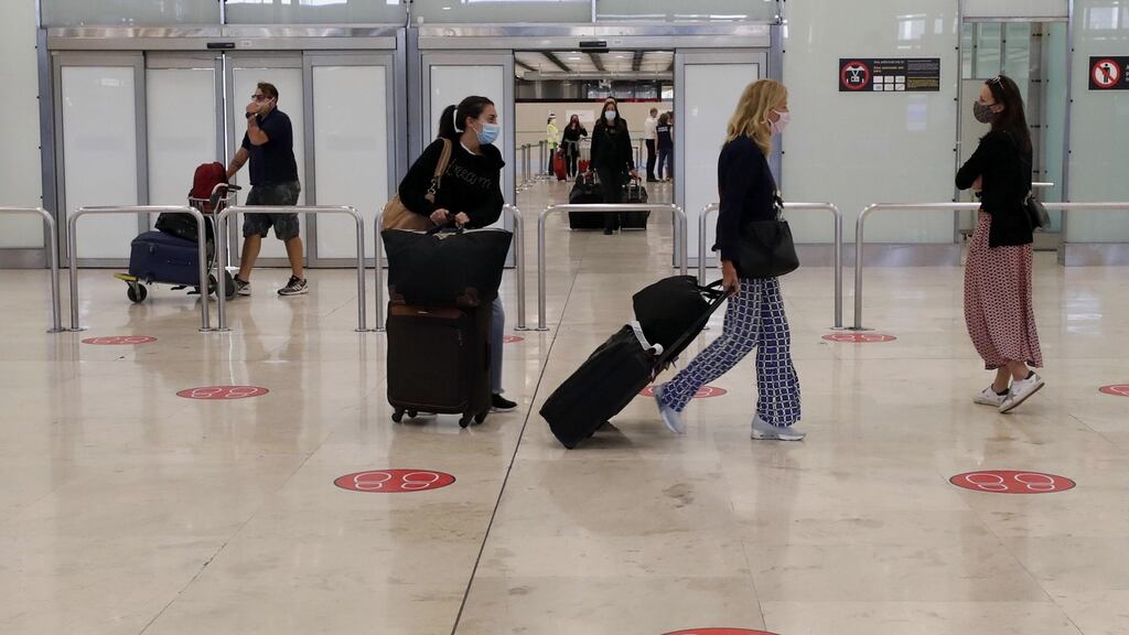 Masked passengers arrive at Madrid’s Barajas airport after restrictions for about three months due to the coronavirus pandemic. Photograph: JJ Guillen