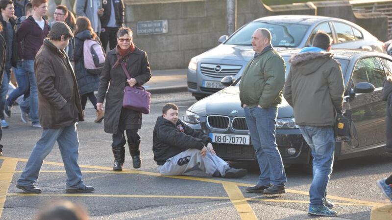 An anti-water charge protester sits infront of traffic on Bachelors Walk in Dublin. Photograph: Alan Betson / The Irish Times.
