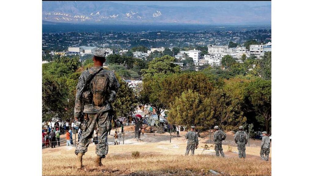 Members of the US 82nd Airborne man the barriers that separate the Pétionville Country Club from the refugee camp