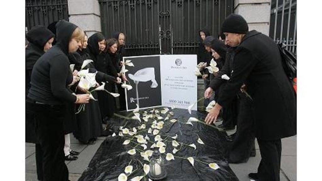 Women's Aid demonstrators lay lillies outside Leinster House during a vigil in memory of women who have been murdered in Ireland in the last nine years.