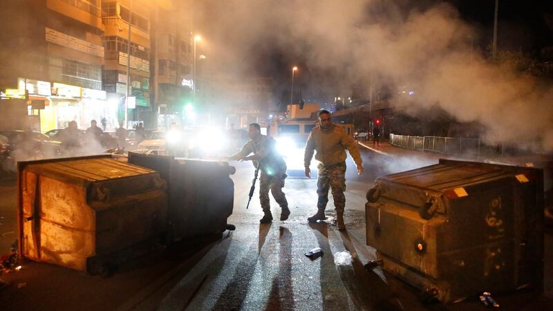 Lebanese army soldiers remove rubbish bins used by protesters to block roads. Photograph: AP