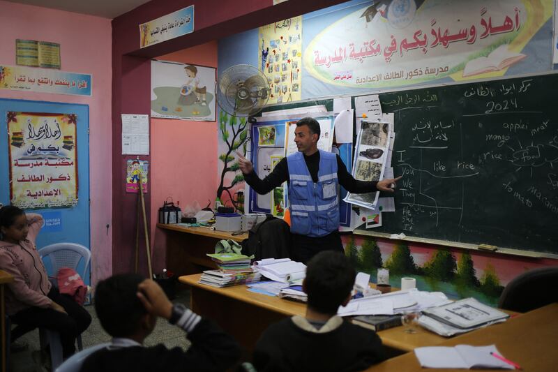 Ismail Wahba, director of the Unrwa Taif School in Rafah, Gaza, teaches an English class in the library of the school housing Palestinians displaced by the conflict between Israel and Hamas. Photograph: Eyad Baba/AFP via Getty Images
