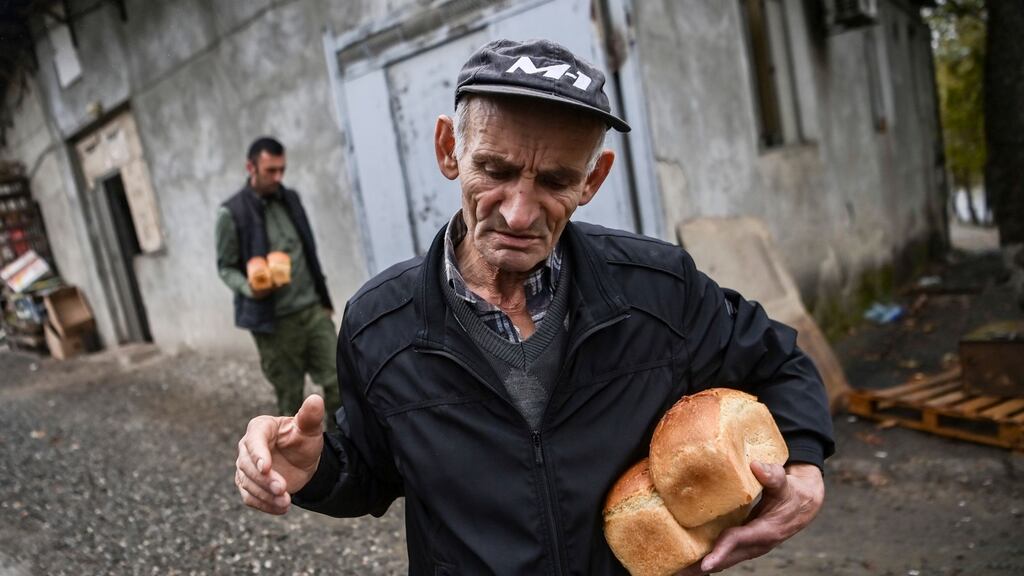 An elderly man receives free bread from a bakery in the city of Stepanakert. Photograph: Aris Messinis/AFP via Getty Images