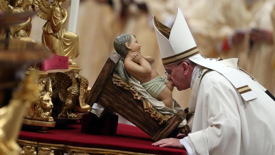 Pope Francis kisses a baby Jesus statue as he leads the midndight Christmas Mass in Saint Peters Basilica at the Vatican late on 24 December 2014. Photograph: Alessandro Di Meo/EPA