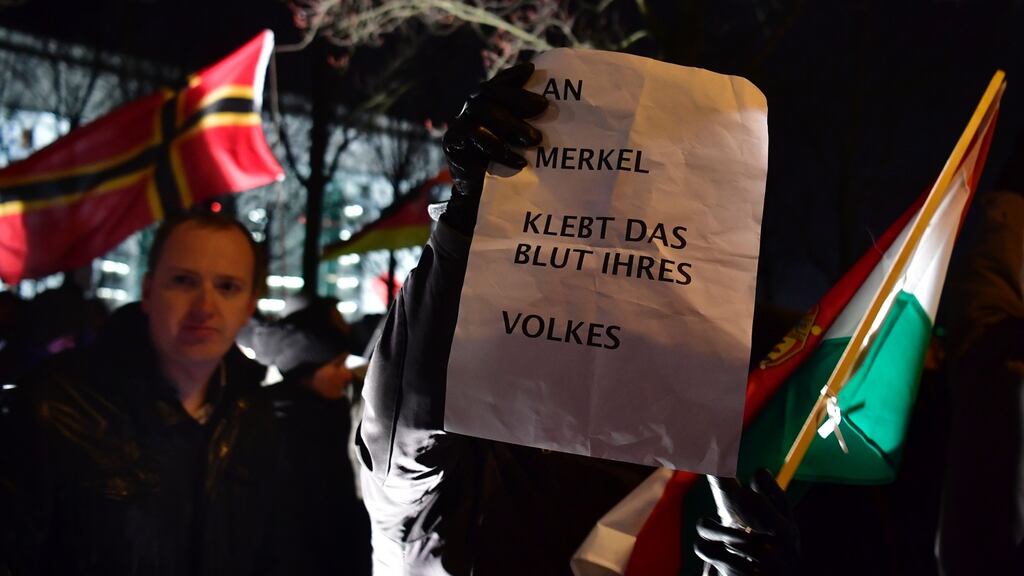 AfD supporters hold a placard that says “Merkel has blood of her nation on her hands” during a protest rally in Berlin. Photograph: John MacDougall/AFP/Getty Images