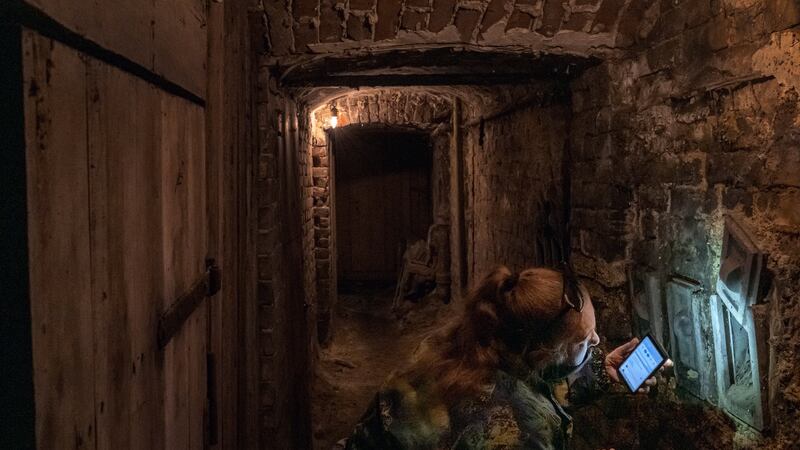 Natalia Kovtun uses the flashlight on her smartphone to check a cubbyhole in her apartment building’s basement bomb shelter in Lviv, Ukraine. Kovtun says she is worried about a saboteur planting a bomb in the shelter. Photograph: Mauricio Lima/The New York Times