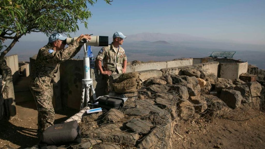 A member of the United Nations Disengagement Observer Force (UNDOF) looks through binoculars at Mount Bental, an observation post in the Golan Heights that overlooks the Syrian side of the Qunietra crossing. Photograph: Baz Ratner /Reuters