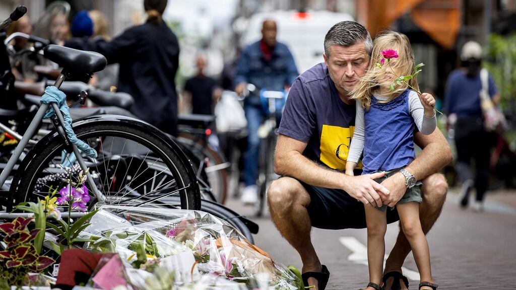 People leave flowers, candles and messages of support to Peter R de Vries in the centre of Amsterdam. Photograph: Koen van Weel/EPA