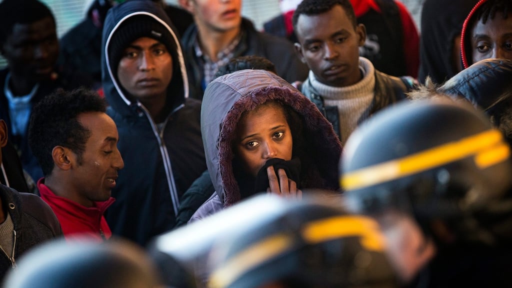 Migrants returning from a process centre set up by the authorities are stopped by riot police at the makeshift camp in Calais known as the “Jungle” on Thursday. Unaccompanied children were among refugees and migrants queuing on outside the warehouses where authorities had carried out registrations earlier in the week, but they remained closed. Photograph: Etienne Laurent/EPA