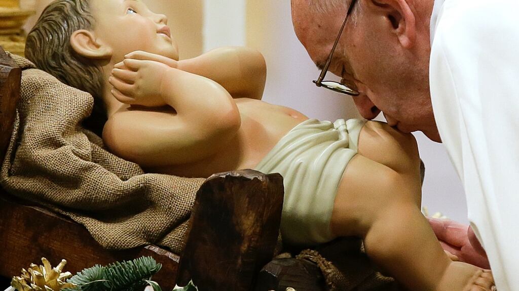 Pope Francis kisses a statue of baby Jesus as he arrives to celebrate New Year’s Day Mass in St Peter’s Basilica at the Vatican. Photograph: Gregorio Borgia/AP