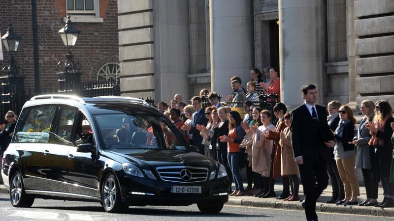 Department of Finance staff applaud as the funeral cortege passes Government Buildings. Photograph: Dara Mac Dónaill