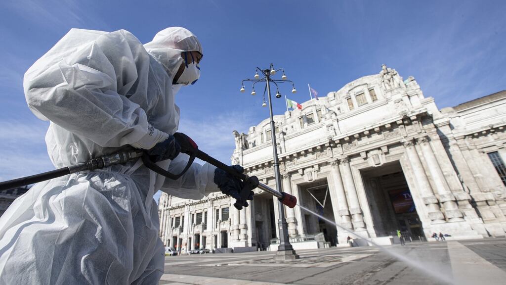 Operators of the Milanese Environmental Services Company (AMSA) sanitise the square of the Central Station using a disinfectant diluted water to avoid further spread of the COVID-19 on Friday. Photograph: Marco Ottico/EPA