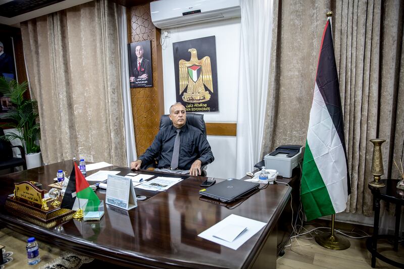 The governor of Jenin, Kamal Abu Al-Rob, at his desk in front of a photo of his son, a doctor who was killed by Israeli security forces in November 2023. Photograph: Sally Hayden