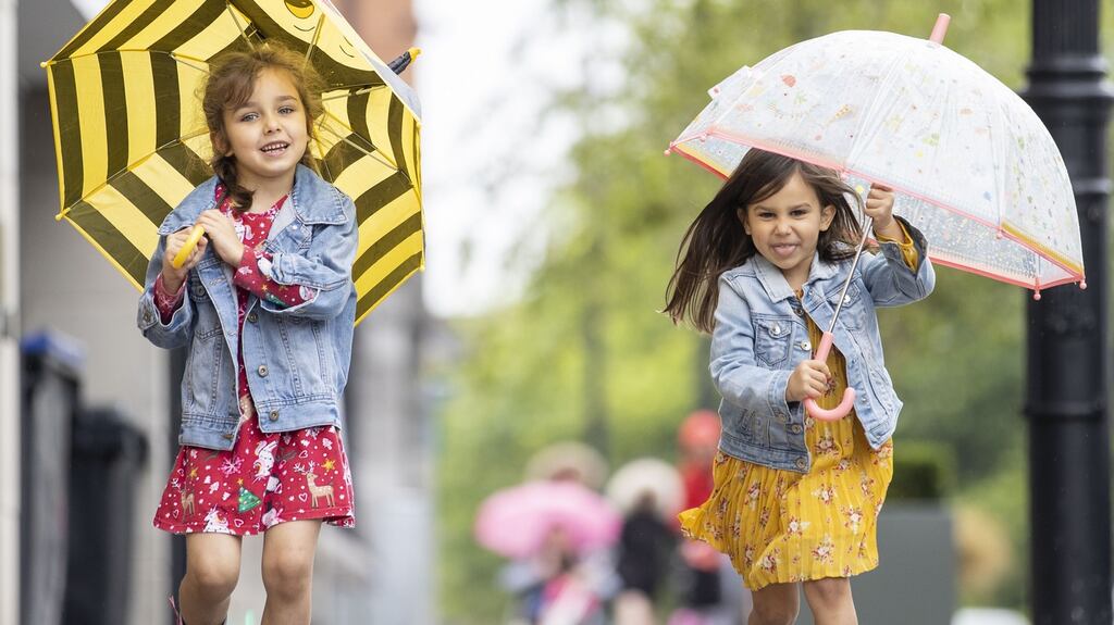 Sister Aoife Lomba (4) and Abbie Lomba (5) from Dublin prepare for the rain. Photograph: Tom Honan
