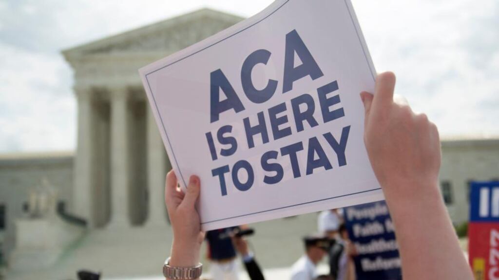 A demonstrator in support of US President Barack Obama’s health-care law, the Affordable Care Act (ACA), holds up a sign after the US supreme court ruled to save Obamacare tax subsidies. Photograph: Andrew Harrer/Bloomberg