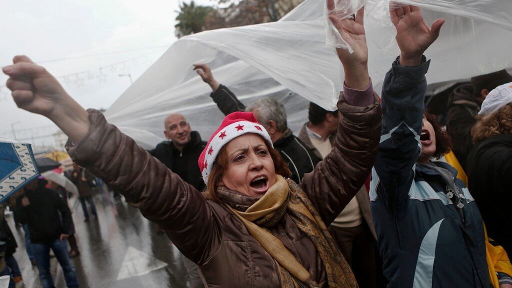 A protester wearing a Santa hat shouts slogans during a rally in Athens on December 17th, 2014. Photograph: Alkis Konstantinidis/Reuters