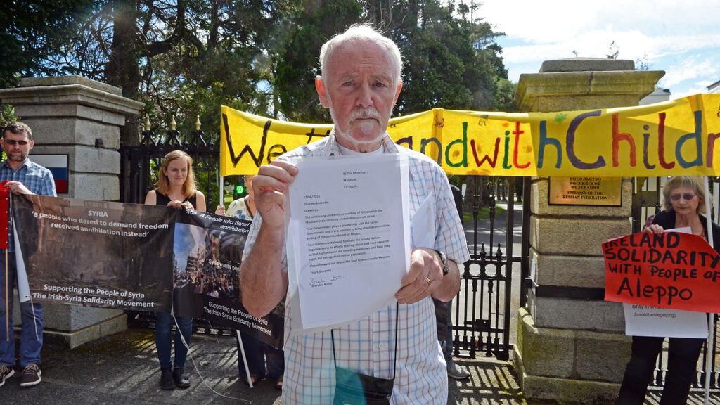 Protest organiser Brendan Butler holds up a letter to be sent to the Russian ambassador to Ireland urging an end to the bombing of Aleppo in Syria. Photograph: Eric Luke/The Irish Times
