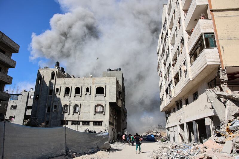 Palestinians watch as smoke rises from a building hit by an Israeli strike in the Rimal neighbourhood of Gaza City on August 21st. Photograph: Omar Al-Qattaa/AFP via Getty