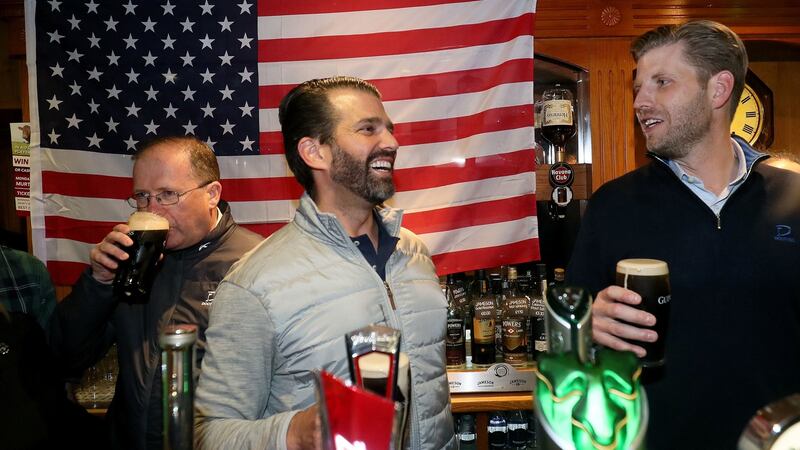 Donald Trump jnr (centre), and Eric Trump (right), behind the bar in Tubridy’s Bar in the village of Doonbeg. Photograph: Brian Lawless/PA